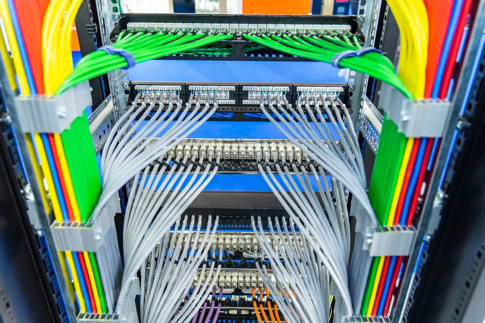 Image of neatly organized network cables in a data center rack.